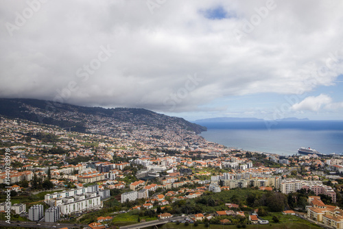 Obraz na płótnie Views of Funchal, Madeira showcasing coastal cityscape and lush hills under cloudy skies w salonie