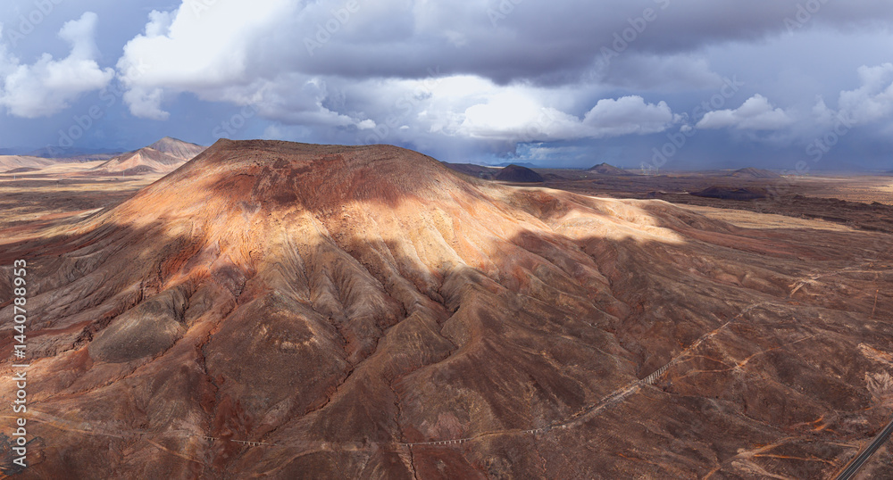 Fototapeta premium Dramatic aerial image of the Barranco Ravine near Montana Roja volcanic mountain landscape after a Rain Storm Water river stream near Corralejo in Fuerteventura Canary Islands Spain 