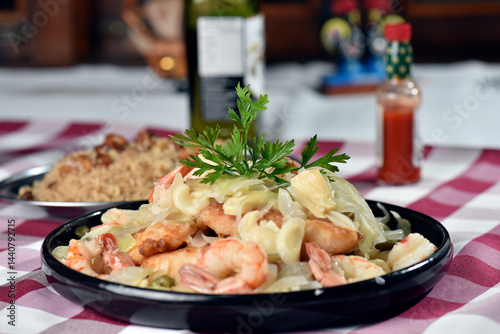 Fototapeta Naklejka Na Ścianę i Meble -  codfish typical Portuguese dish baked cod with onion garlic peppers and potatoes rustic Portuguese food salted fish cooked olive oil