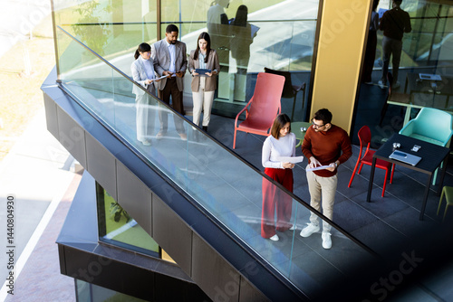Group of professionals collaborating on project details in modern office space during sunny day