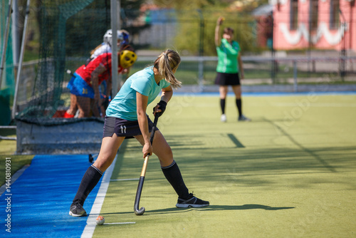 Young Female Player Performing Corner Strike in Field Hockey Game