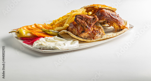 Grilled Chicken Plate with Rice, Fries, Flatbread, and Middle Eastern Appetizers Isolated on White Background

