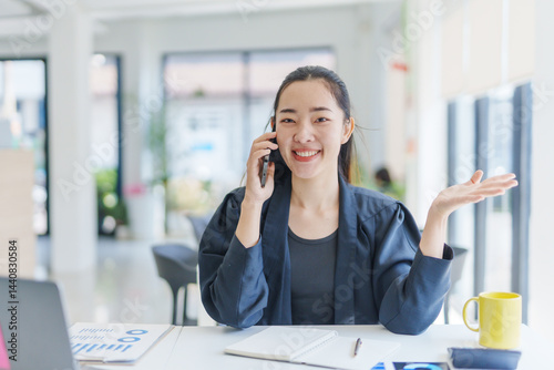 Asian businesswoman using smartphone explaining project during business meeting in modern office