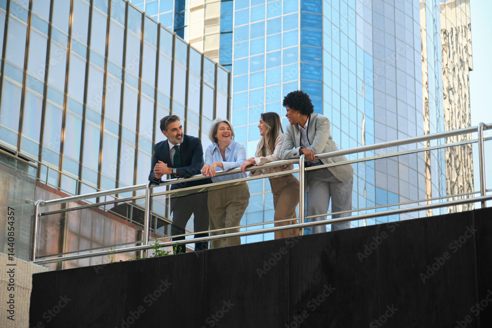 Businesspeople talking and laughing on a balcony in the financial district