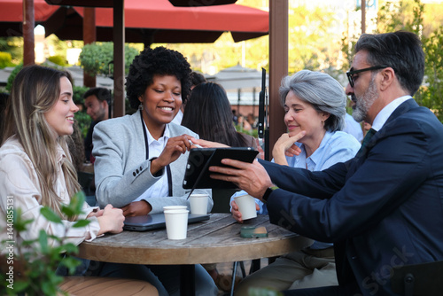 Obraz na płótnie Businesspeople using tablet and laptop during a meeting at outdoor cafe w salonie