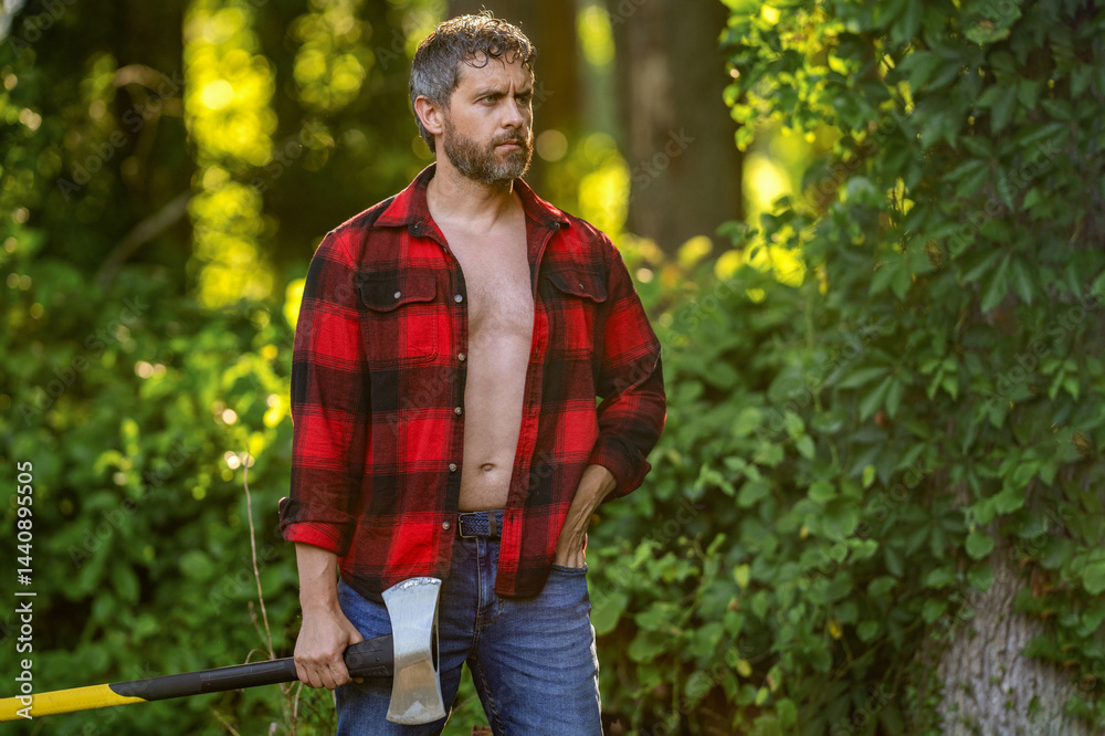 Fototapeta premium Man with logging axe. Brutal man in unbuttoned shirt. Lumberjack hardworking outdoor. Brutal lumberjack, copy space. Brutality and masculinity. Hispanic lumberjack man with axe. Lumberjack axe
