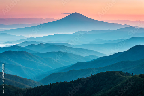 Obraz na płótnie Serene sunset hues create a breathtaking panorama of rolling hills and mountains, forming a tranquil landscape bathed in soft pastel light.
w salonie