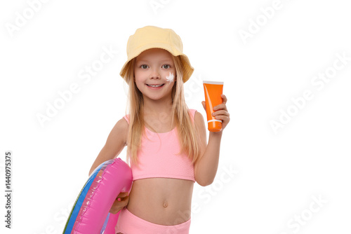 Smiling little girl with tube of sun protection product and inflatable ring on white background
