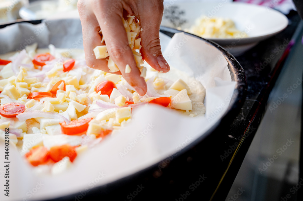 Close-up scene of female hands. Adding a mixture of three cheeses - mozzarella, parmesan and gorgonzola to the dough on the kitchen countertop. Making homemade pizza with three types of cheese - femal