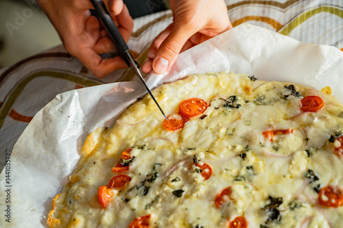 Obraz na płótnie Cutting fresh homemade pizza with scissors w salonie