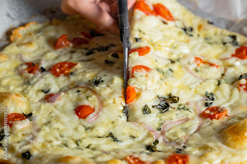 Cutting fresh homemade pizza with scissors