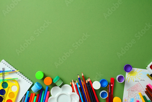 Quadro su tela Kids art supplies flat lay on green background with copy space