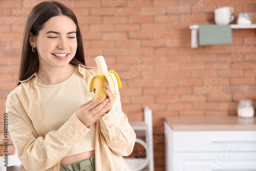 Young woman eating banana i...