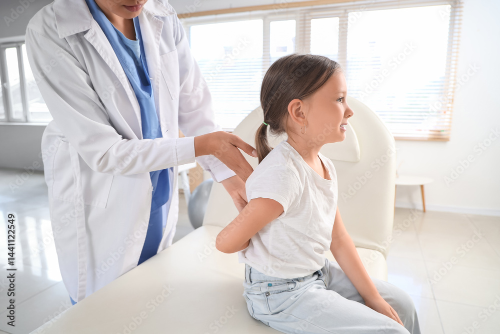 Fototapeta premium Female osteopath working with little patient in clinic