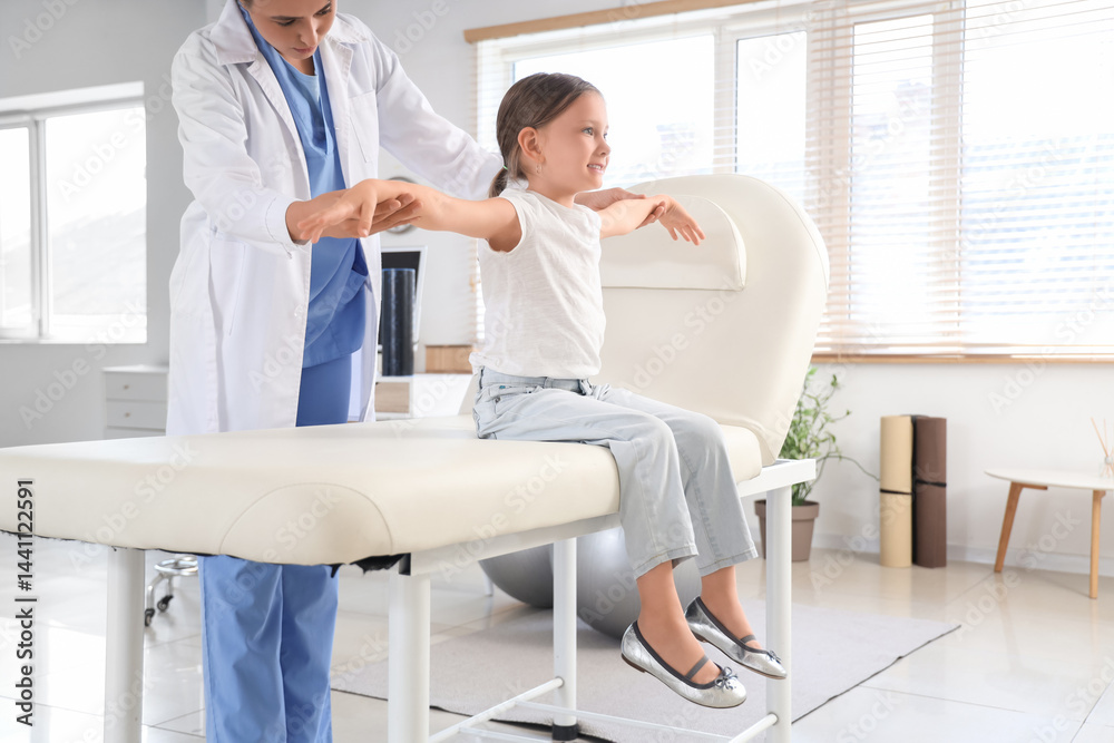 Fototapeta premium Female osteopath working with little patient in clinic