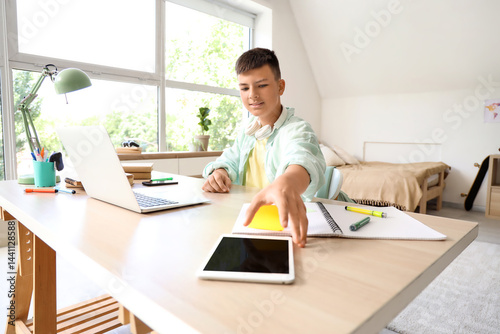 Teenage boy studying at hom...