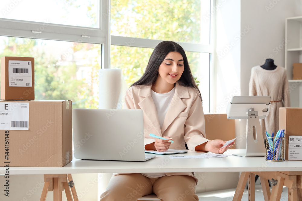 Pregnant seller working at table in online store warehouse Pregnant seller working at table in online store warehouse