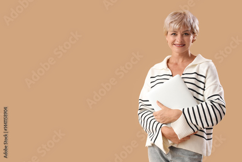 Mature woman with laptop on...