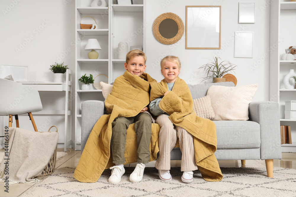 Obraz premium Kids with plaid sitting on sofa at home