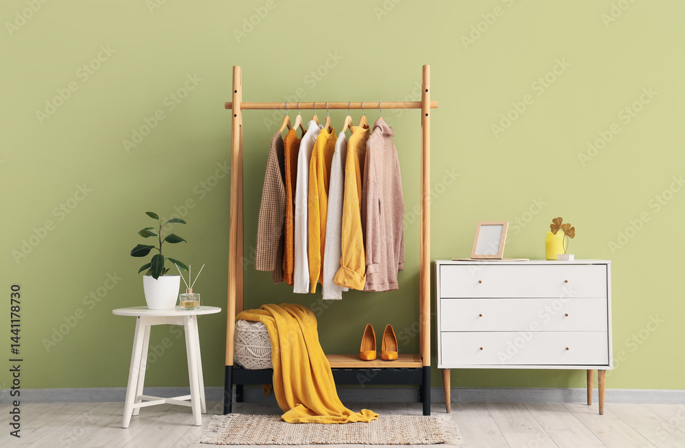 Interior of dressing room with clothes rack, table and drawers