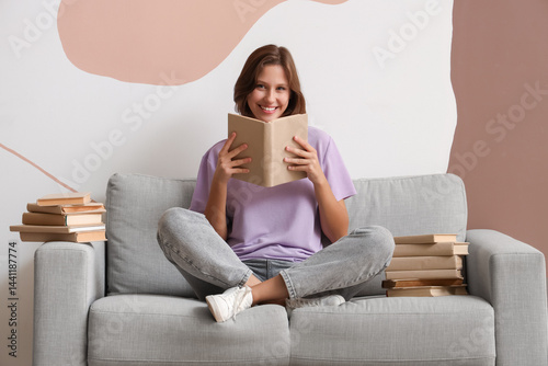 Education and lifelong learning, happy young woman reading a book while sitti...