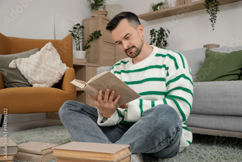 Handsome man reading book o...