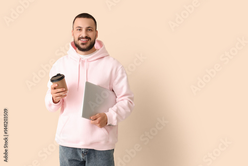 Young man with laptop drink...