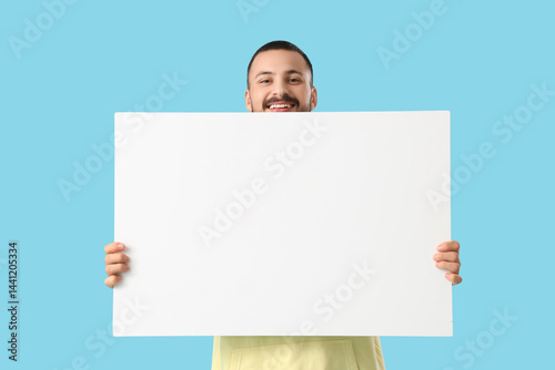 Young man with blank poster...