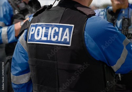 Obraz na płótnie Policía - Marca POLICIA en la parte posterior de un chaleco antipuñalamiento de alta visibilidad usado por oficiales de policía local y policía nacional en la escena de un incidente