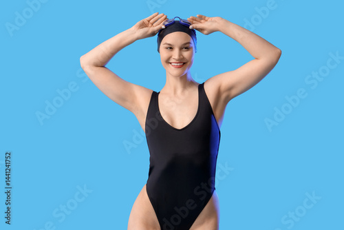 Female swimmer on blue  bac...