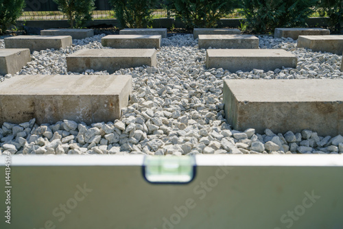 Obraz na płótnie Spirit level on top of concrete blocks. Preparation for garden shed foundation w salonie