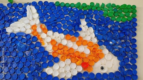 Colorful fish mosaic crafted from bottle caps. photo
