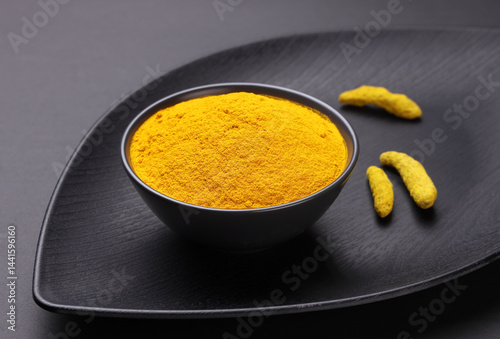 Fototapeta Naklejka Na Ścianę i Meble -  Indian spice called turmeric powder and roots isolated on black background 