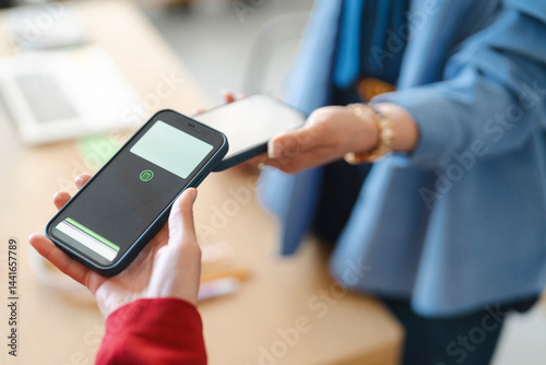 A customer is paying a vendor by tapping their phones together. This is a quick and easy way to transfer money.