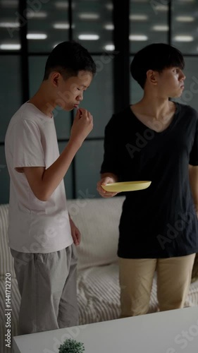 Brother sitting and eating snacks at home.