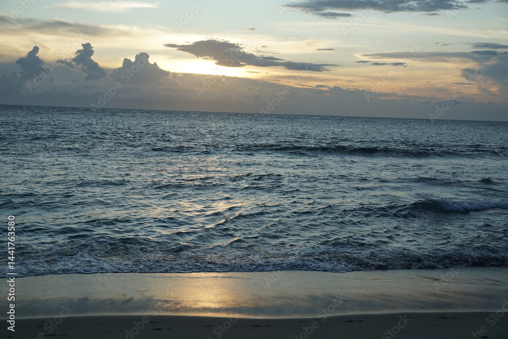 Fototapeta premium Sunset serenity over ocean waves tropical beach nature photography calm atmosphere wide angle tranquility and beauty