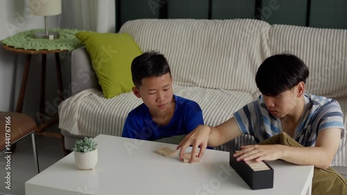Brother and younger brother play board games together.