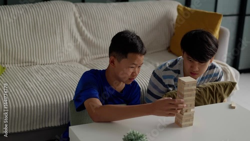 Brother and younger brother play board games together.