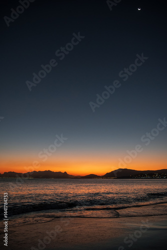 Sunset Over Itaipu Beach with Crescent Moon in the Sky - Niteroi, Rio de Janeiro, Brazil