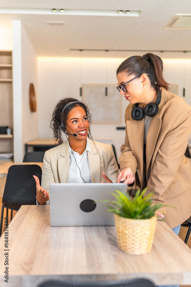 Customer service representatives working together on a laptop in the office