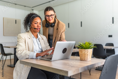 Obraz na płótnie Telemarketers working together on a laptop in modern office w salonie