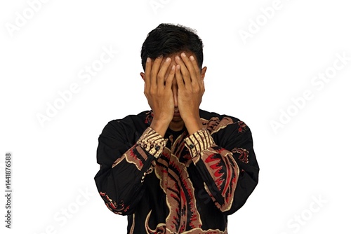Asian man covers face facing camera showing stressed expression photo