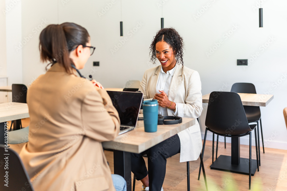 Businesswomen collaborating on project in modern office space