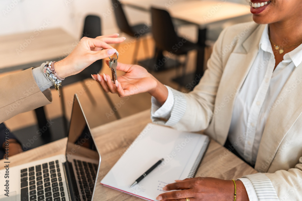 Real estate agent giving keys to a new homeowner after signing contract
