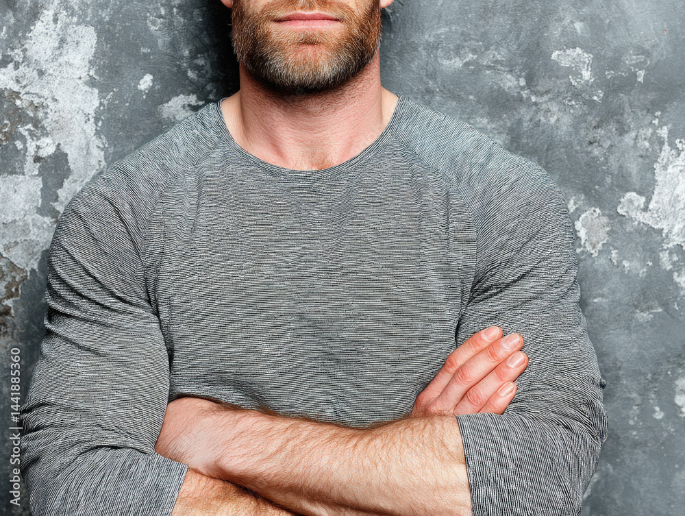 A casual image of a man folding his arms, wearing a t-shirt