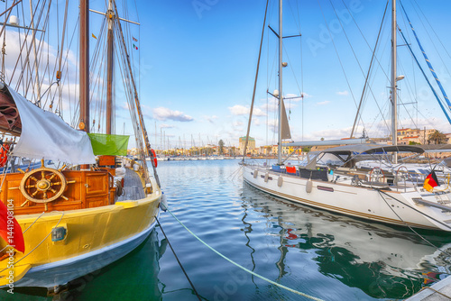 Unbelivable summer view of the Alghero Marina yacht port at the Gulf of Alghero with anchored sailboats.