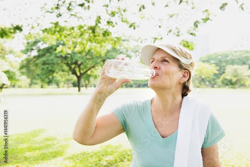 Принти на полотні Mature Caucasian woman drinking water in a park