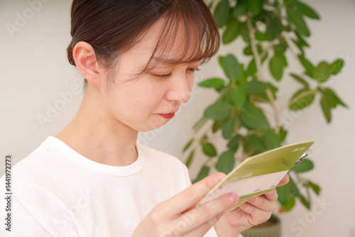 通帳を見て複雑な表情をする女性