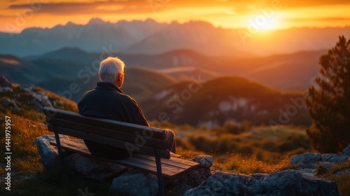 An elderly man sits peacefully on a bench at a scenic overlook. He gazes at a breathtaking mountain landscape illuminated by the warm golden light of sunset, reflecting fulfillment
