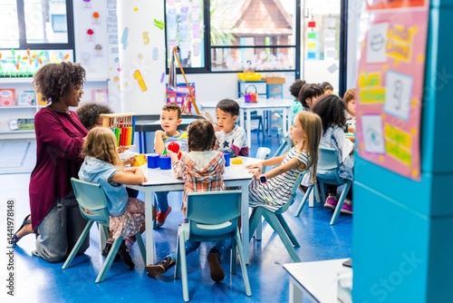 Diverse classroom with children and a teacher. Kids of various ethnicities learning together. Teacher guiding students in a colorful classroom setting. Teacher working with elementary school children.